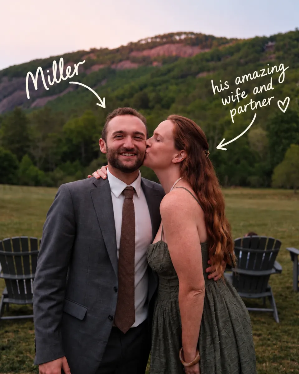 Miller in a gray suit, smiling while his wife kisses his cheek, with mountains behind them and handwritten labels that read "Miller" and "his amazing wife and partner."
